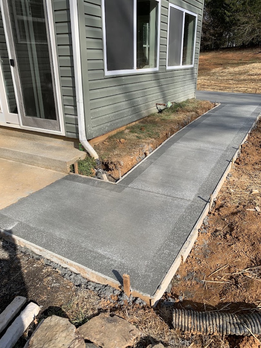A concrete sidewalk running alongside a home, poured by T. Archer Concrete