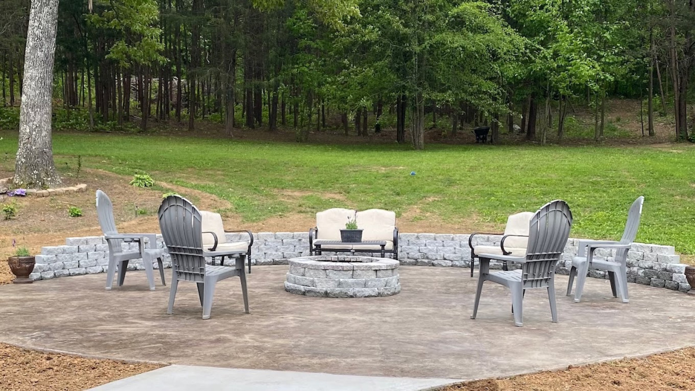 A finished concrete patio with a fire pit and seating wall, poured by T. Archer Concrete