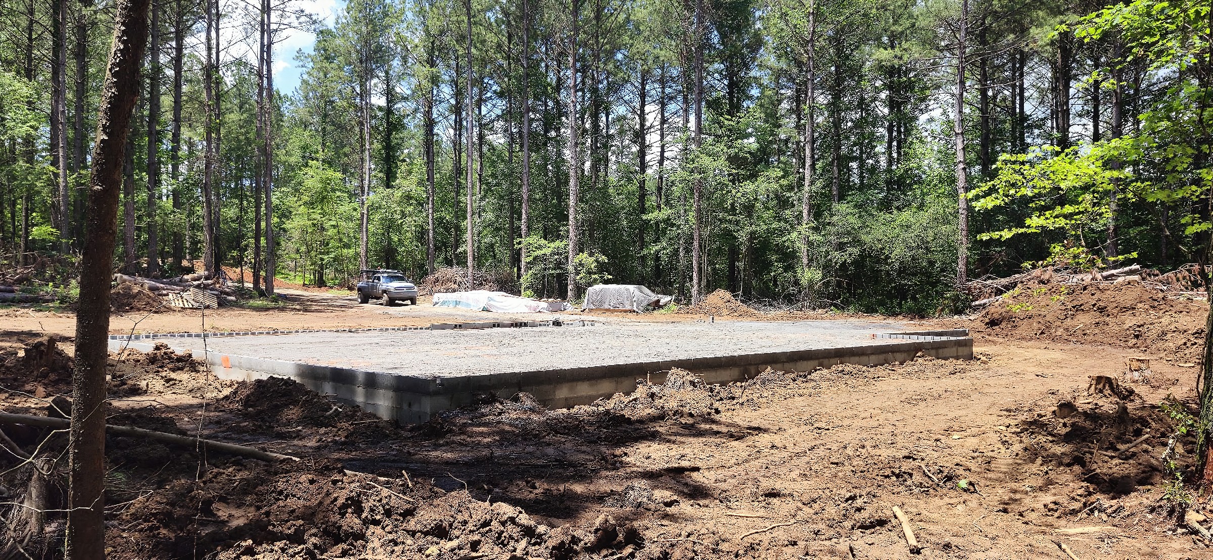 A concrete slab and block foundation poured by T. Archer Concrete on a wooded lot in East Tennessee