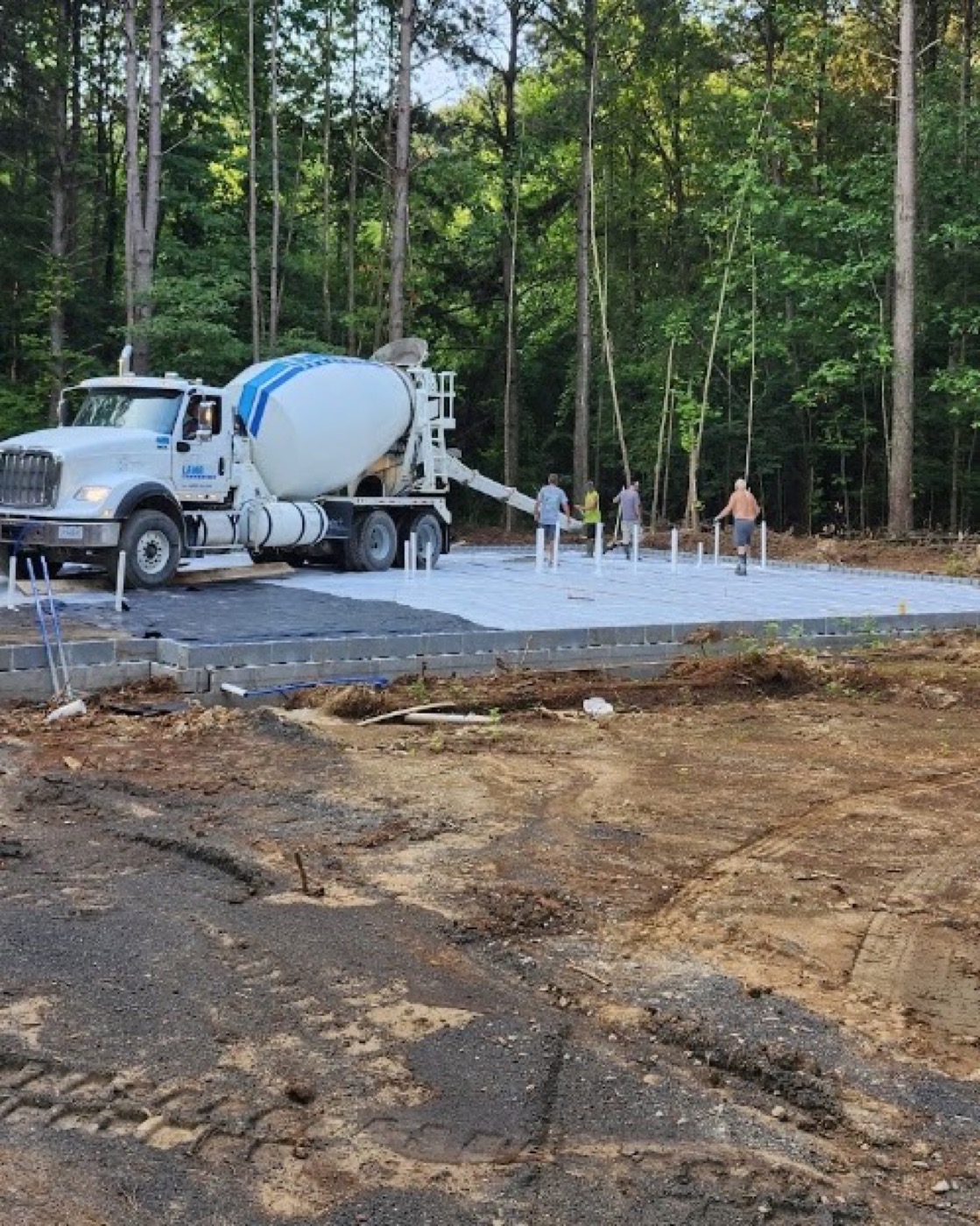 A concrete truck and Tim Archer's crew screeding a fresh slab pour near Friendsville, Tennessee