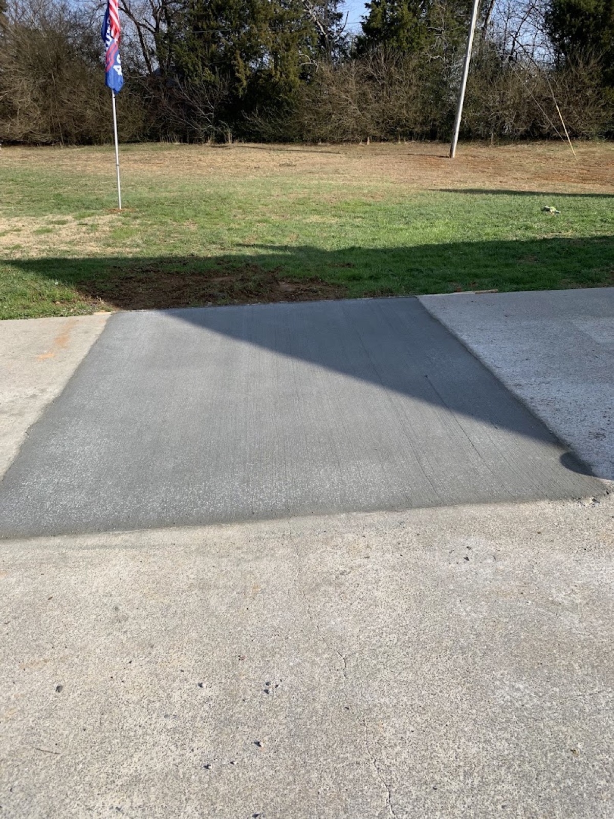 A concrete sidewalk running across a lawn, poured by T. Archer Concrete