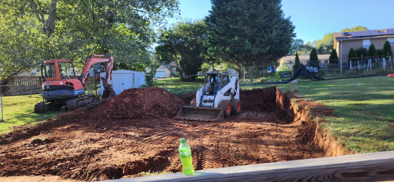 A skid steer moving dirt during site prep for a concrete pour near Friendsville, Tennessee
