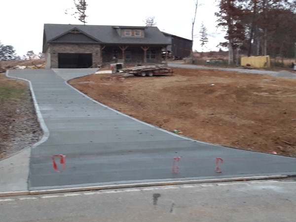 A wide concrete driveway running up to a barn-style home in East Tennessee