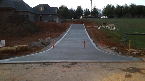 A long concrete driveway running out to the road at an East Tennessee property