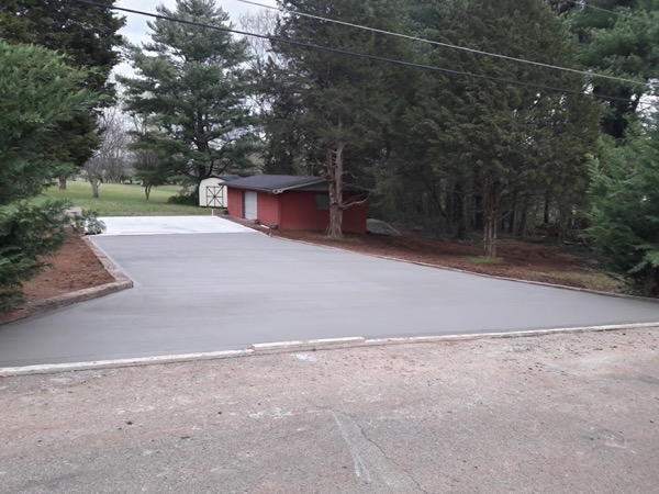 A concrete driveway apron finished at the roadside