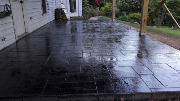 A stamped concrete porch, freshly sealed and still wet