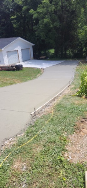 A curving concrete driveway leading to a detached garage