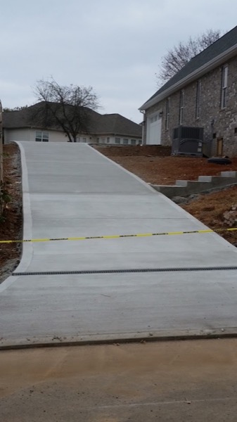 A broad new concrete driveway beside a home