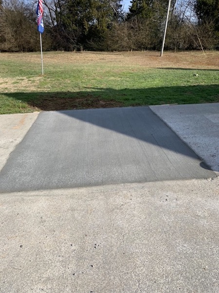 A concrete sidewalk running across a front lawn