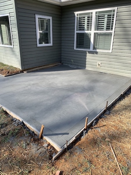 A concrete patio slab poured against the side of a home