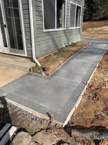 A concrete sidewalk poured alongside a home
