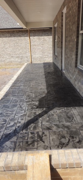 A stamped concrete driveway with a patterned finish