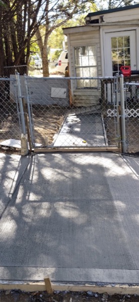 A concrete walkway leading up to a gate
