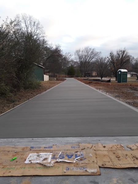 A fresh concrete driveway poured on a rural lot